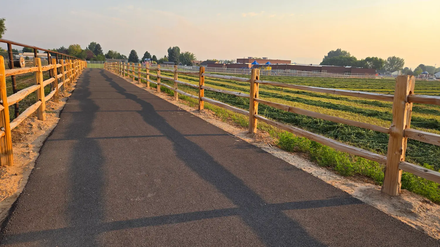 A paved trail beside a field.