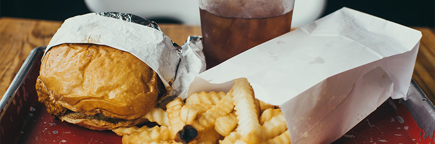 Photo of some crinkle fries and a sad, smashed burger sandwich thing.